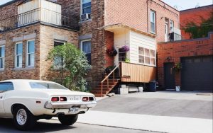 A car in a driveway beside a residential house located in Lake Worth